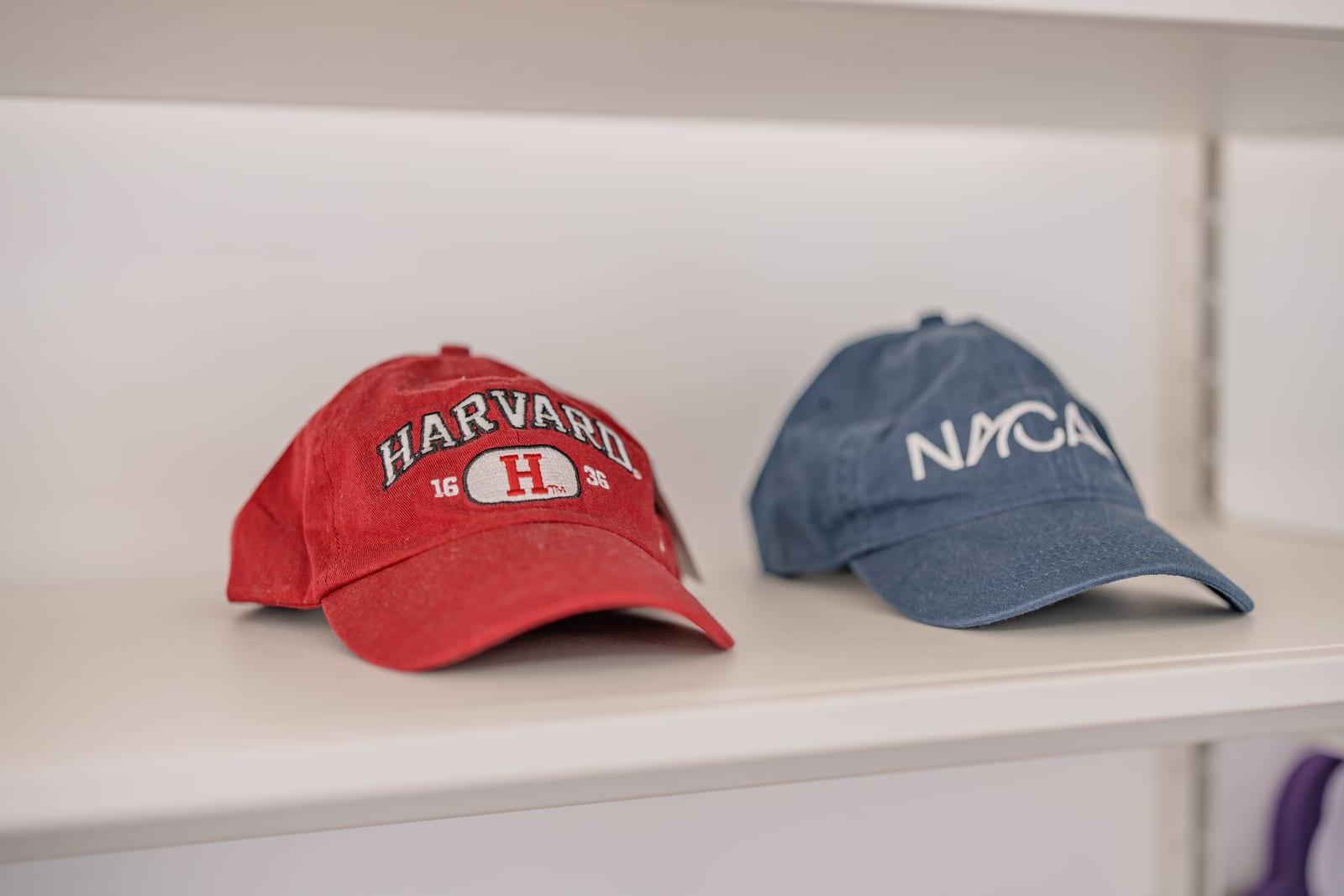 Harvard·NACAC 볼캡이 놓인 선반