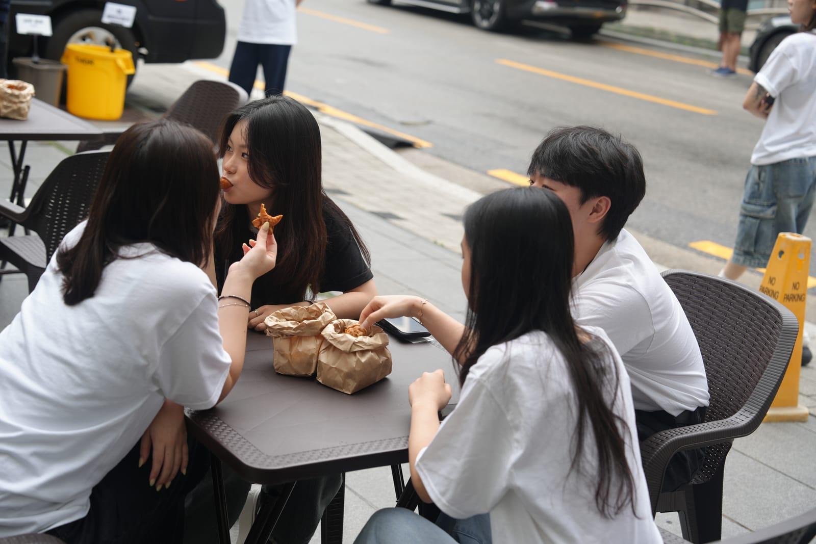 야외 테이블에서 간식을 나누는 학생들