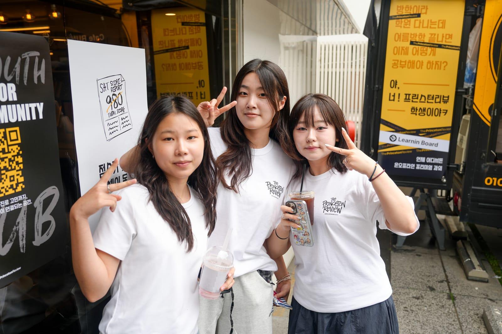 커피트럭 배너 앞에서 음료를 들고 포즈를 취한 참가 학생들