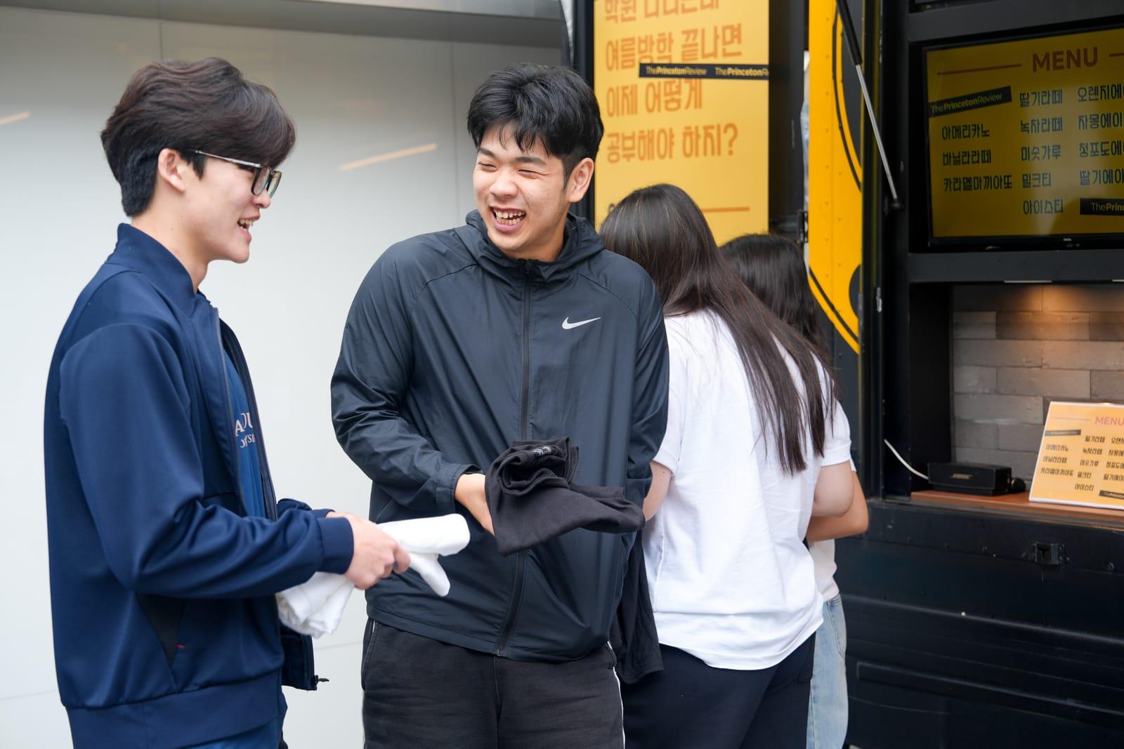 행사 기념 티셔츠를 받아 들고 환하게 웃는 학생들