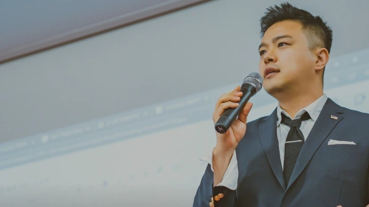 마이크를 들고 SAT 커리큘럼을 강연하는 모습